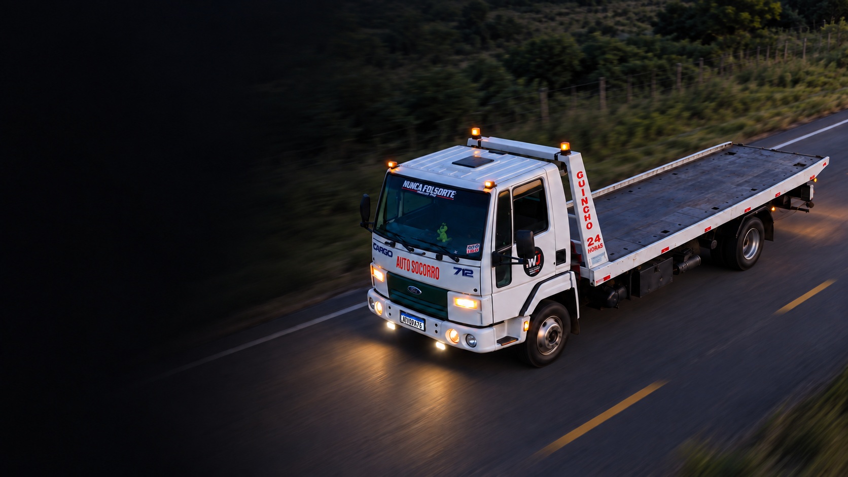 Guincho da WJ Auto Socorro visto de cima, em movimento numa rodovia ao entardecer